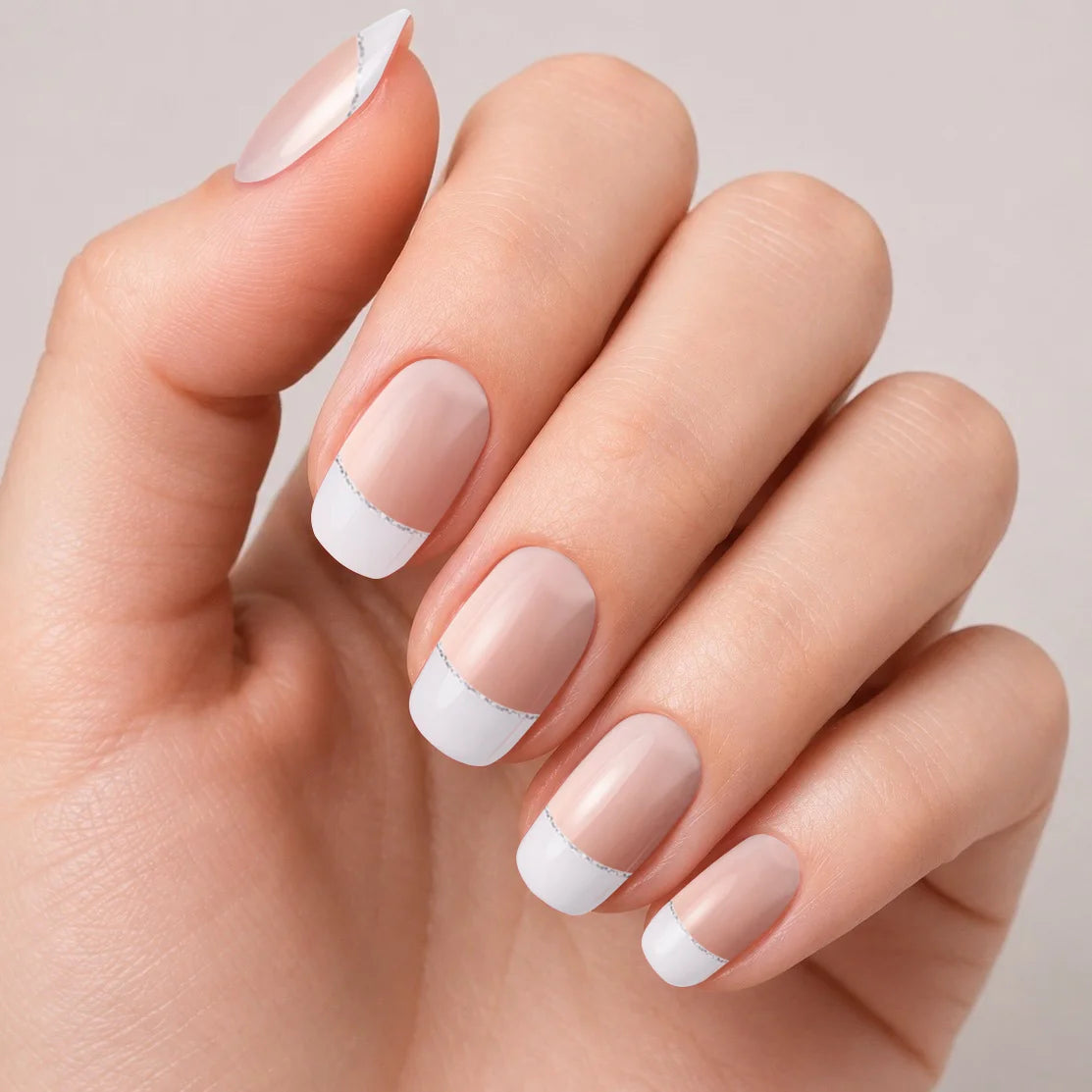 Bandes de vernis gel semi-permanent Geloria French Silver posées sur une main