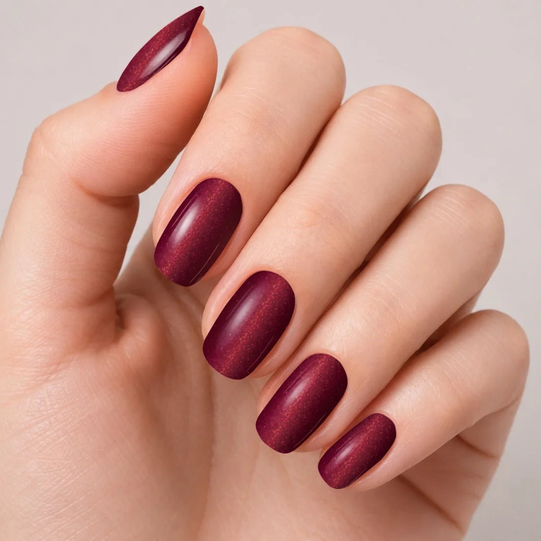 Bandes de vernis gel semi-permanent Geloria Cat Eye Wine posées sur une main