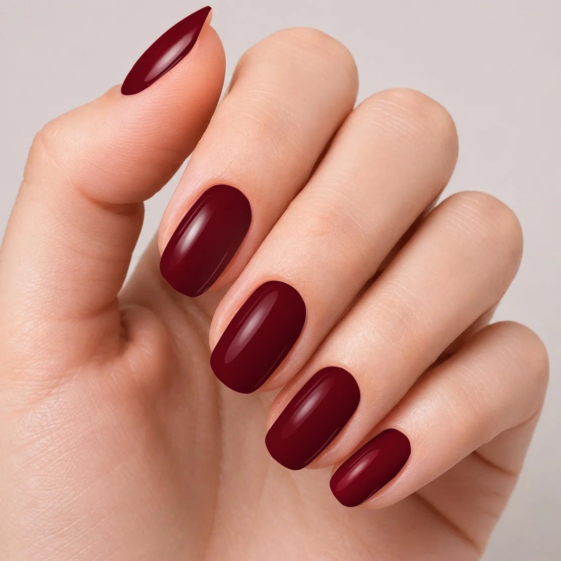 Bandes de vernis gel semi-permanent Geloria Merlot posées sur une main